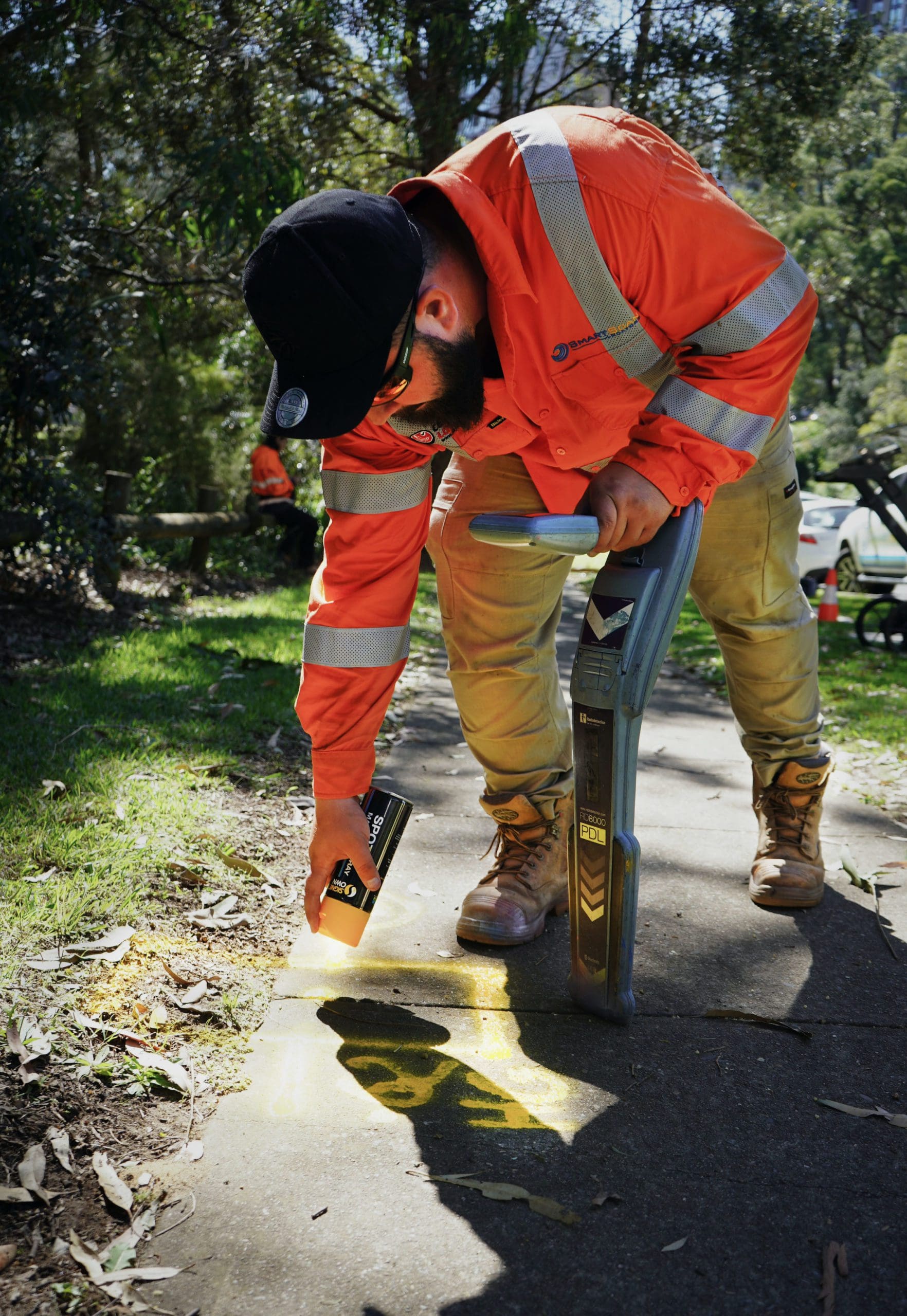 Service locator marking a residential footpath before excavation